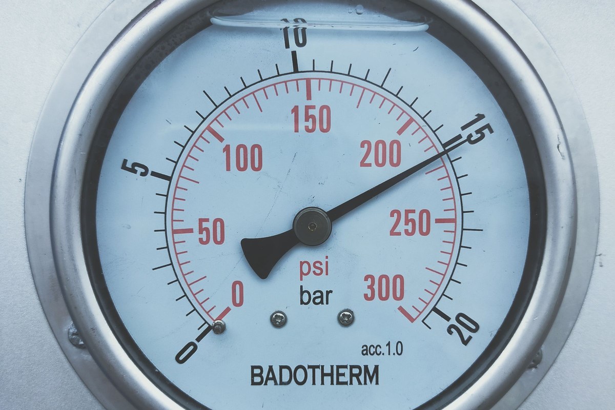 A pressure gauge on a compressed air receiver showing system pressure in bar