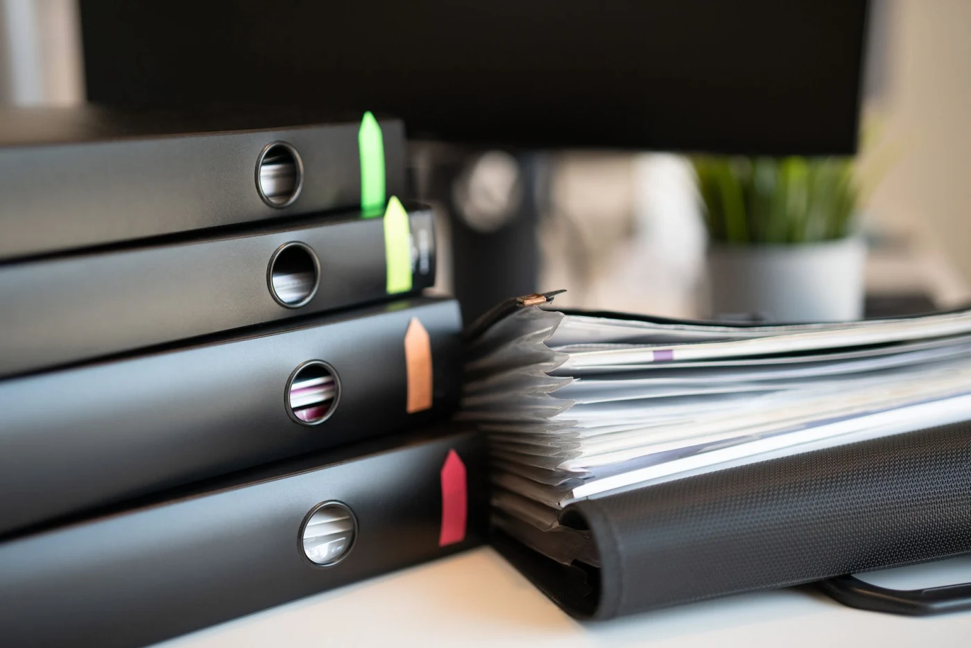 Ring binders and a document file on a desk, representing the written report issued after an energy audit