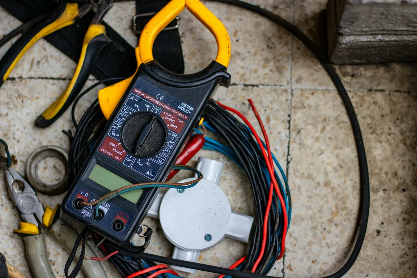Clamp meter and electrical cabling used to measure power draw during a compressed air energy audit