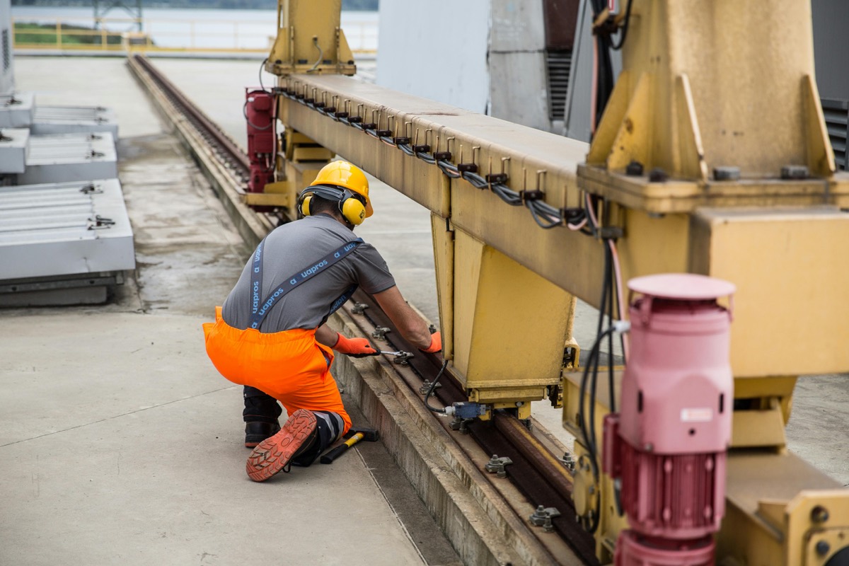 Engineer in hi-vis servicing industrial plant machinery, the kind of planned air compressor servicing Air-Mech carries out on site.