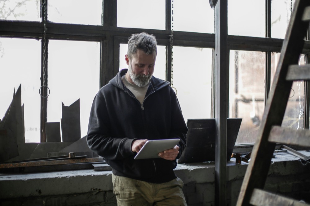 Service engineer logging a job on a tablet, reflecting Air-Mech's digital service records and 48-hour photo reports.